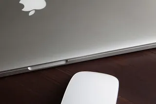 MacBook Pro笔记本电脑和木制桌上的神奇鼠标