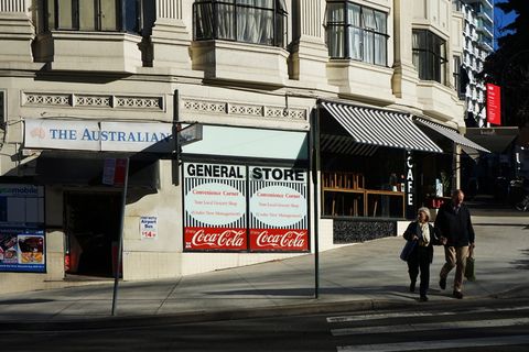 一对夫妇在商店附近的路上行走的照片