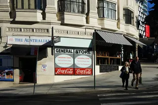 一对夫妇在商店附近的路上行走的照片