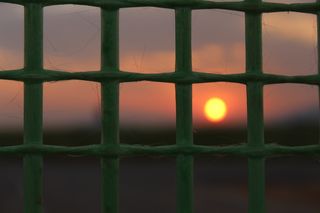 特写摄影，金属网架，日落，太阳，地平线，天空，太阳日落，傍晚