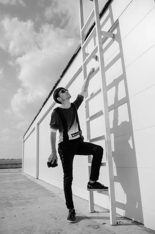 站在*旁边的人的灰度照片