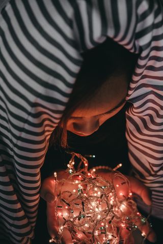 拿着白色细绳灯的女人
