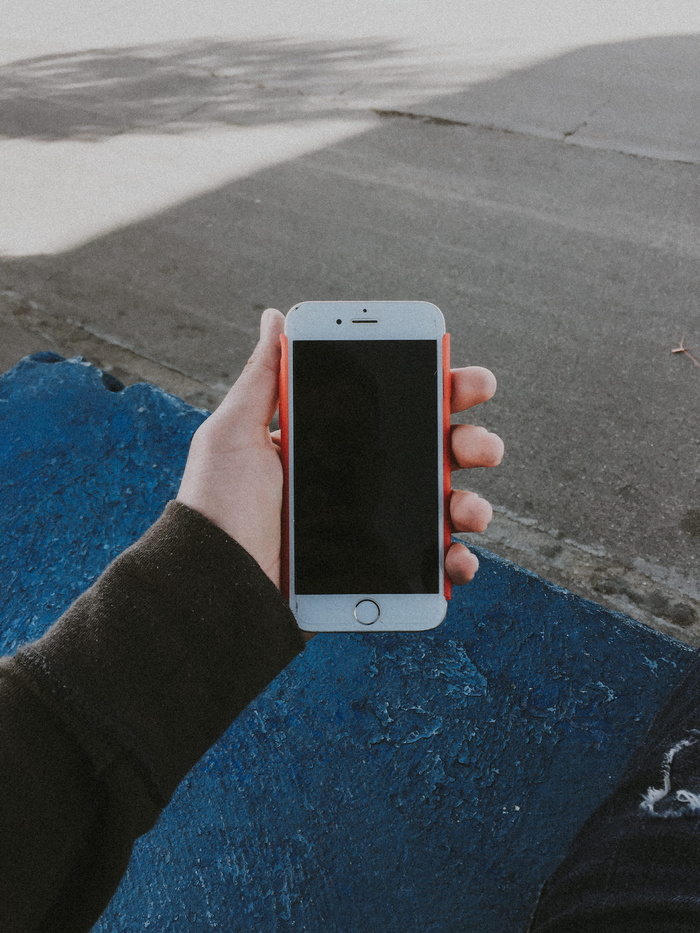 手持已关闭金色iPhone 6的人