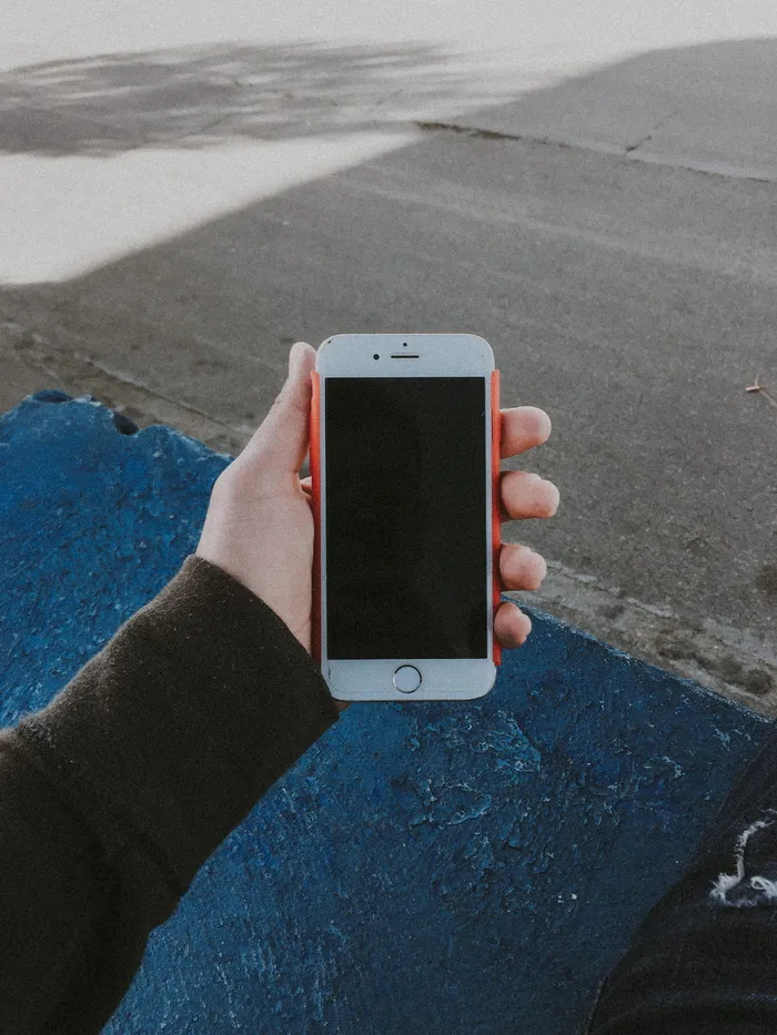 手持已关闭金色iPhone 6的人