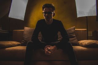 坐在沙发上的黑色圆领长袖衬衫的男人