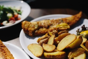 reastaurant餐厅晚餐：鱼和烤土豆配新鲜希腊沙拉