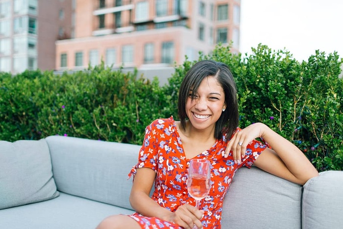 坐在灰色沙发上穿着红白花朵V领连衣裙的女士