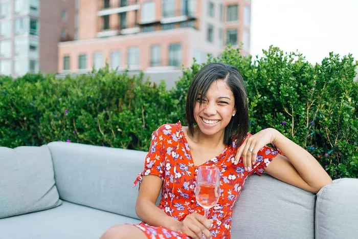 坐在灰色沙发上穿着红白花朵V领连衣裙的女士