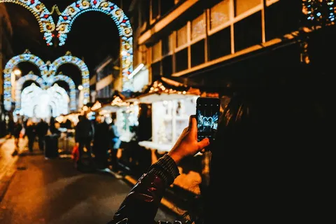 晚上站在建筑物之间拍照的女人 晚上站在建筑物之间拍照的女人