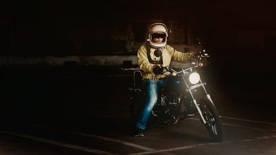 戴白色全脸头盔骑标准摩托车的男子