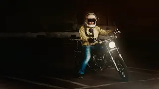 戴白色全脸头盔骑标准摩托车的男子