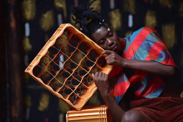 一个人靠在塑料瓶箱上的照片