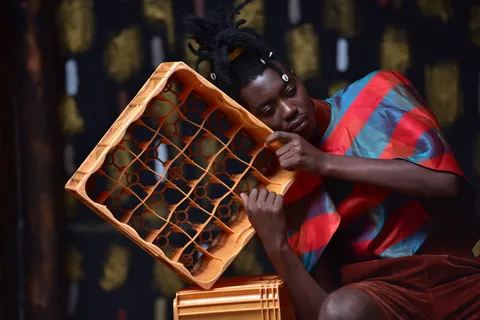 一个人靠在塑料瓶箱上的照片