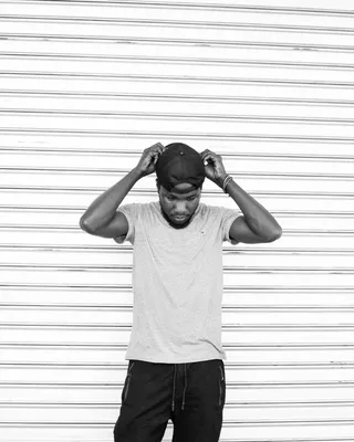 男子摸帽子的单色照片