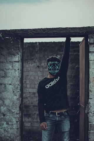 男子身穿黑色阿迪达斯长袖衬衫，戴口罩