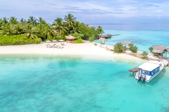 米色海滩，白天在碧蓝平静的海水旁有小屋和休息室