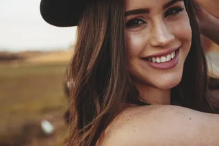 戴黑帽子的微笑女人的选择性聚焦