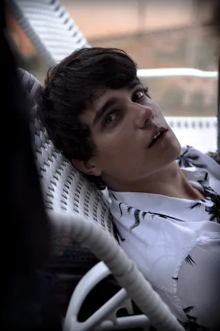 身穿黑白休闲衬衫的男子坐在椅子上