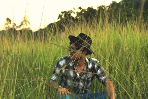 坐在绿色草地上的男子