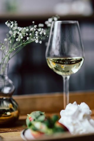 木托盘上的草莓、奶油和白葡萄酒