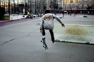 穿灰色毛衣的男子在滑板上翻转