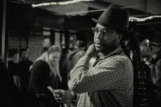 男子穿着连衣裙衬衫，头戴软呢帽