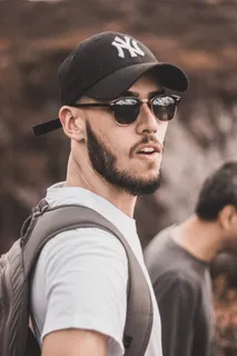 男子戴黑色贴身帽子,身穿白色圆领衬衫 男子戴黑色贴身帽子,身穿白色圆领衬衫