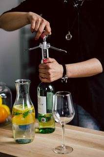 双手用开瓶器打开酒瓶