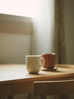 桌子上有两个白色和红色的杯子 桌子上有两个白色和红色的杯子