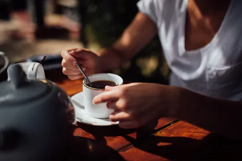 拿着白色陶瓷杯子的人 拿着白色陶瓷杯子的人