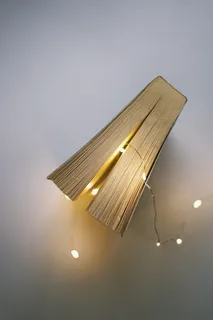 白色表面灰色细绳灯旁的合书 白色表面灰色细绳灯旁的合书