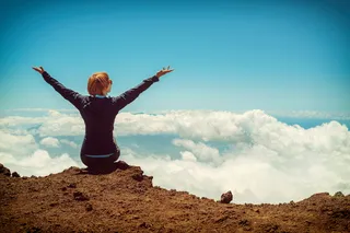 坐在悬崖上的人举起双手