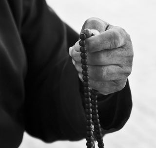 拿着串珠项链的人