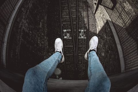 穿着蓝色粗斜纹棉布水洗合身牛仔裤和白色低帮运动鞋的人