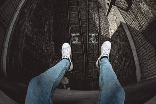 穿着蓝色粗斜纹棉布水洗合身牛仔裤和白色低帮运动鞋的人