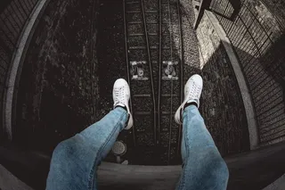 穿着蓝色粗斜纹棉布水洗合身牛仔裤和白色低帮运动鞋的人