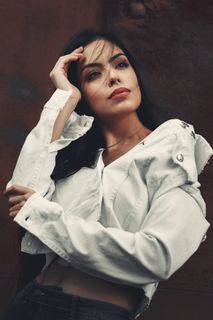 身穿白色牛仔夹克和黑色牛仔裤的女子的照片