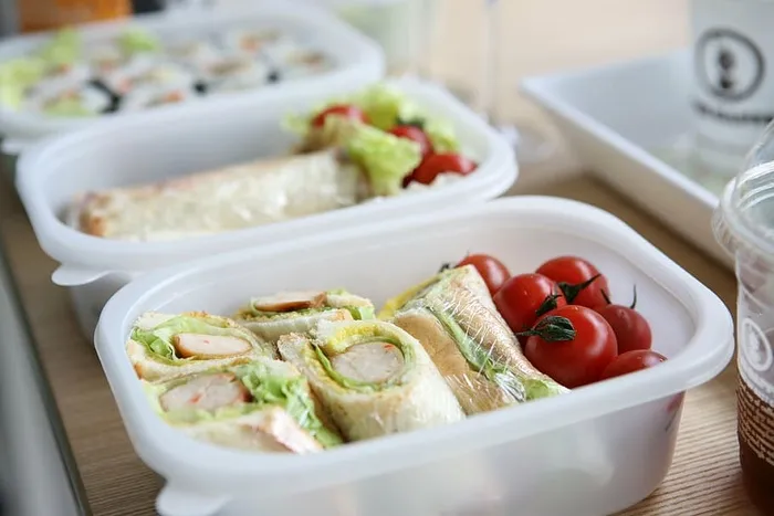 两个，白色塑料容器，三明治，西红柿，午餐盒，野餐，食物和饮料