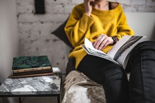 躺在床上看杂志的年轻女子