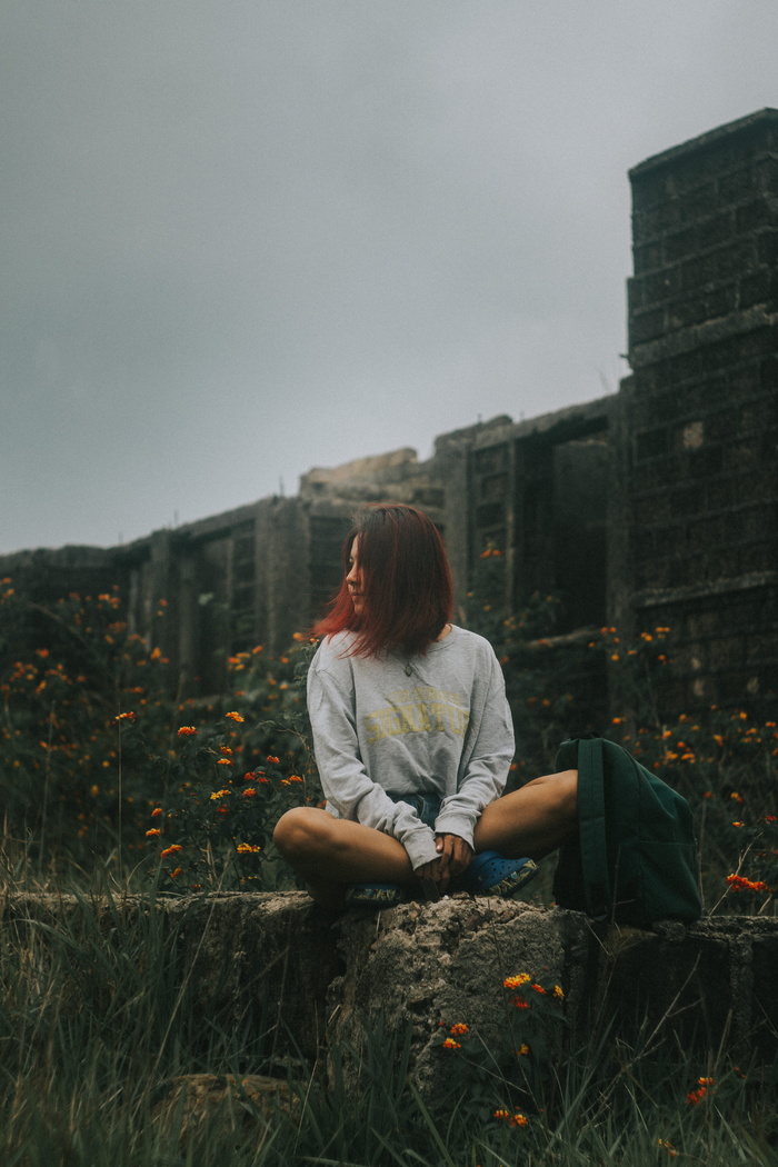 坐在混凝土栅栏上的女人