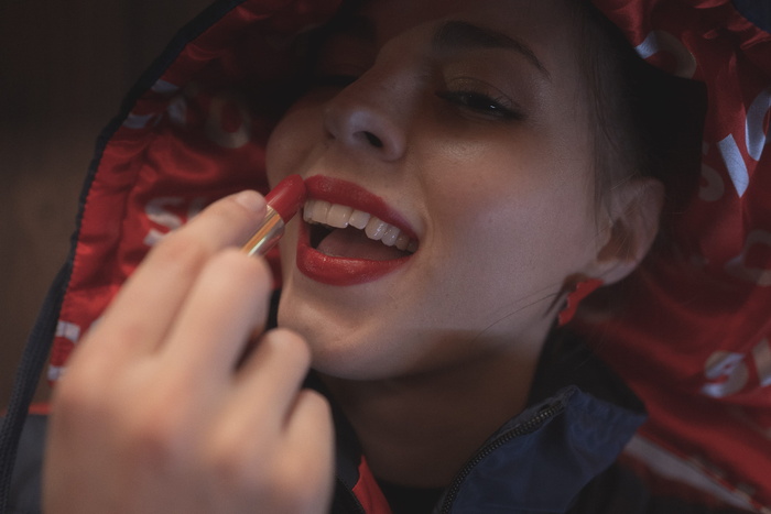 女人涂红色口红的照片