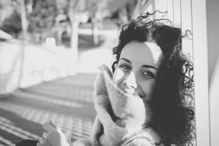 一个女人靠在白色柱子上的灰度照片