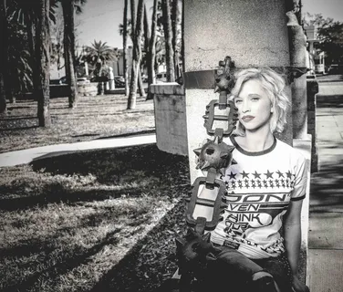 坐在灰色水泥柱旁的女人灰度照片