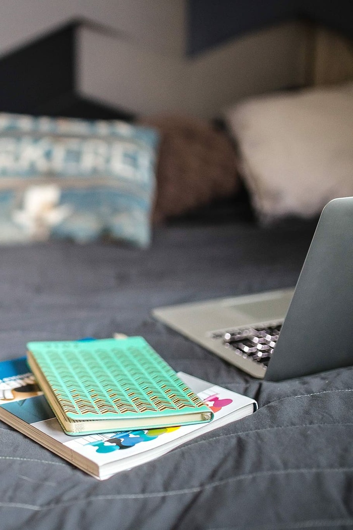 床上有书的笔记本电脑