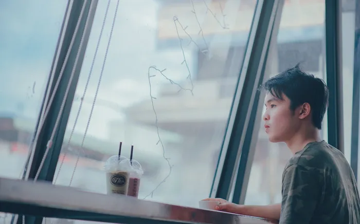 坐在桌子旁塑料杯旁的男子