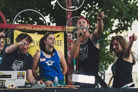 一名身穿黑色背心的男子指着话筒