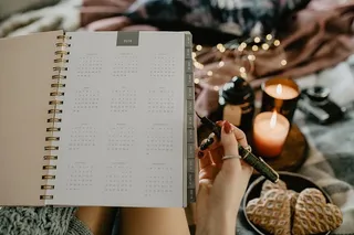 躺在床上的笔记本上写东西，里面有咖啡、蜡烛和姜饼