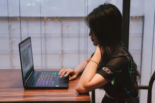 坐着使用笔记本电脑的女人