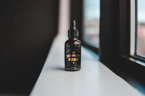靠近窗户的黑色和金色标签滴管瓶 靠近窗户的黑色和金色标签滴管瓶