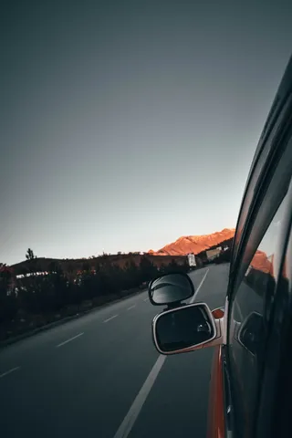 左侧灰色车辆侧后视镜反射道路